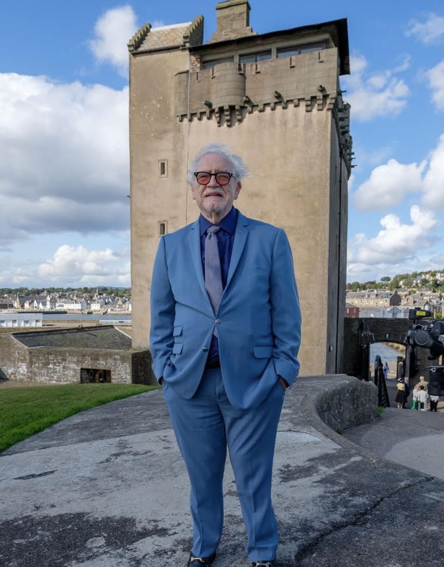 Brian Cox standing on the castle ramparts